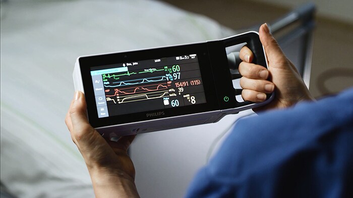 a person holding a mobile patient monitoring device