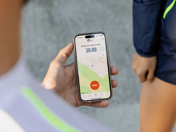A participant in the run is checking their phone, waiting for the start to run.